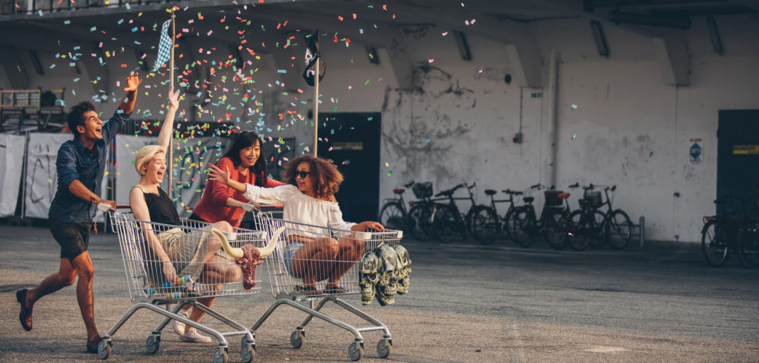 Multiethnic young people racing with shopping trolleys © jacoblund/GettyImages