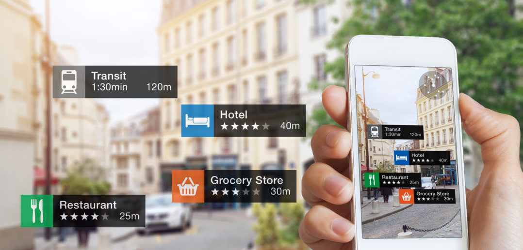 Augmented Reality (AR) information technology about nearby businesses and services on smartphone screen guide customer or tourist in the city, close-up of hand holding mobile phone, blurred street